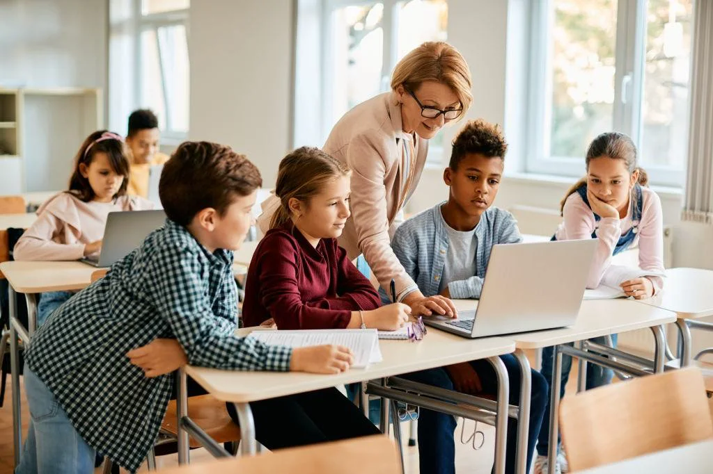 Students learning with an educator around a classroom table