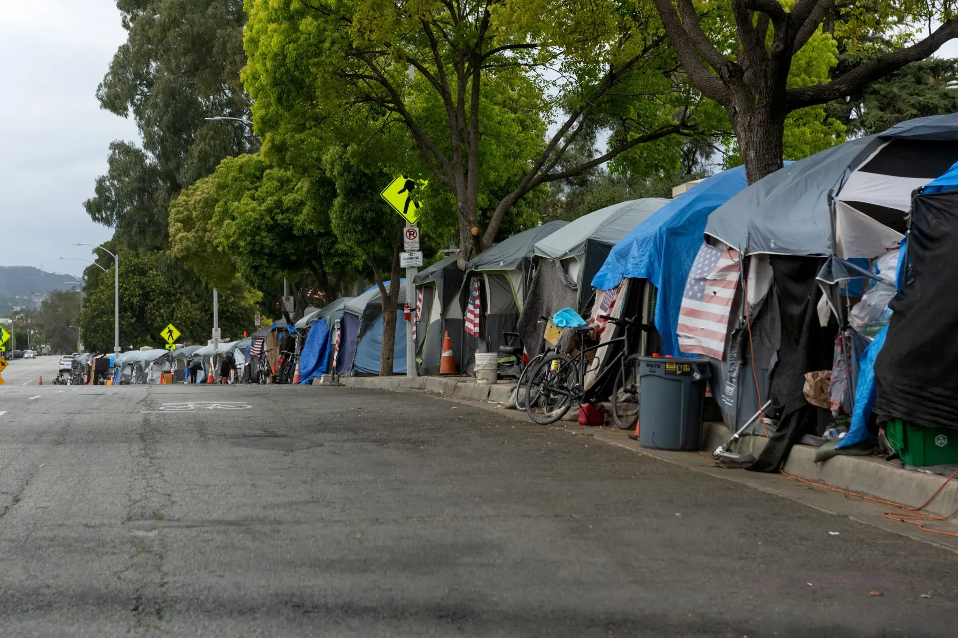 A city street with temporary shelters, illustrating the need for stable housing